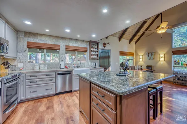 a kitchen with stainless steel appliances granite countertop a sink stove and cabinets