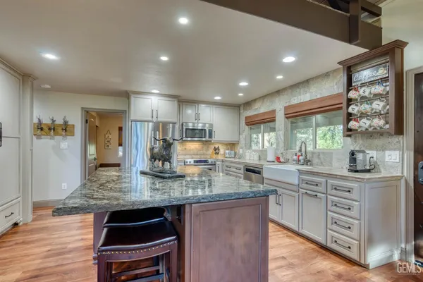 a kitchen with stainless steel appliances granite countertop a sink stove and refrigerator