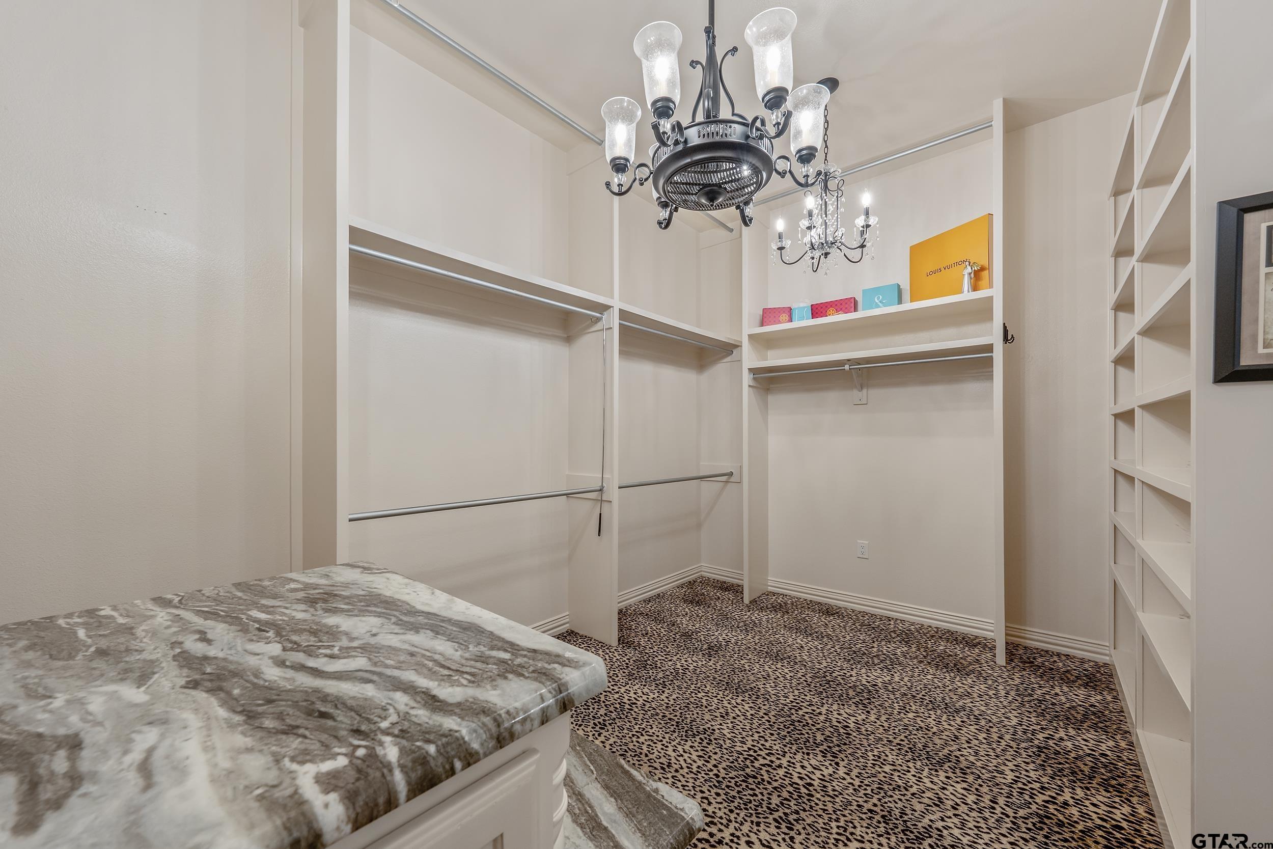 17521 Biltmore Circle Tyler, TX 75703 - Photo 26 of 48 a bedroom with a bed and a chandelier