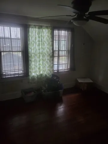 a living room with hardwood floor and a ceiling fan
