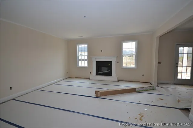 an empty room with a fireplace and windows