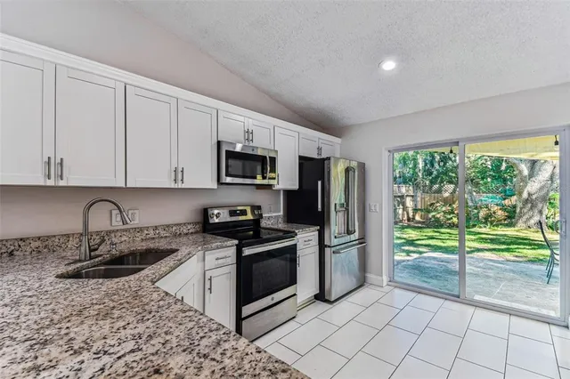 a kitchen with stainless steel appliances granite countertop a stove a sink and a refrigerator