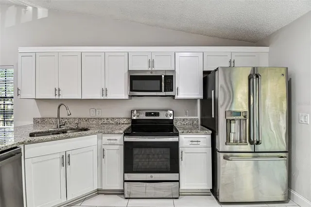 a kitchen with white cabinets and stainless steel appliances