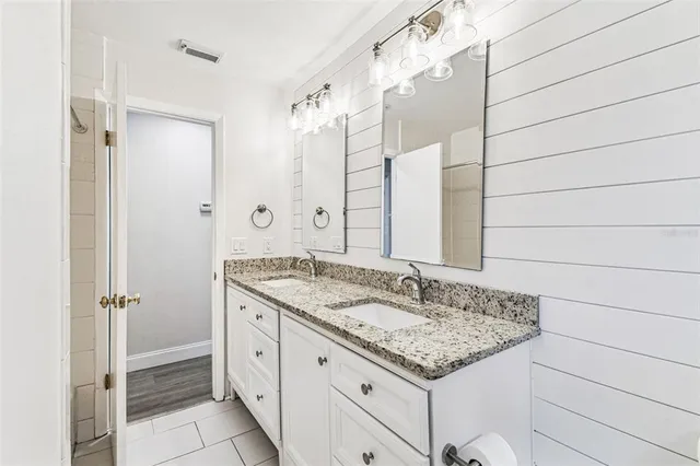 a bathroom with a granite countertop sink and a mirror