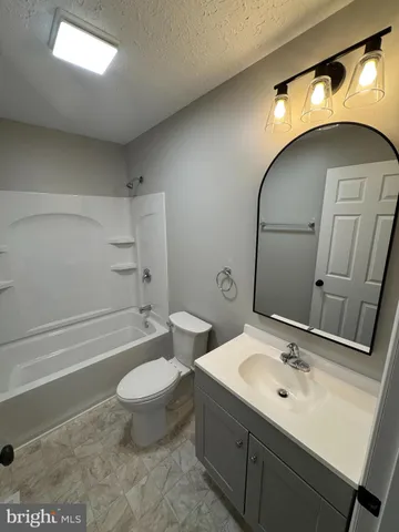 a bathroom with a sink and mirror with toilet
