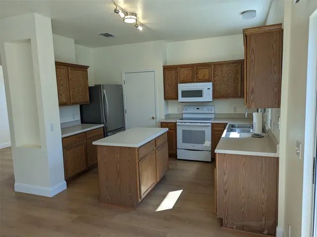 a kitchen with a stove top oven and refrigerator