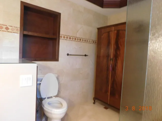 a bathroom with a toilet a sink and mirror