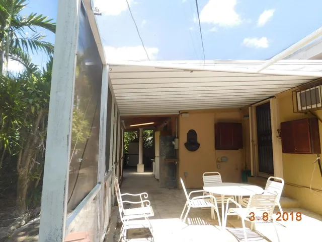 a patio with table and chairs and potted plants