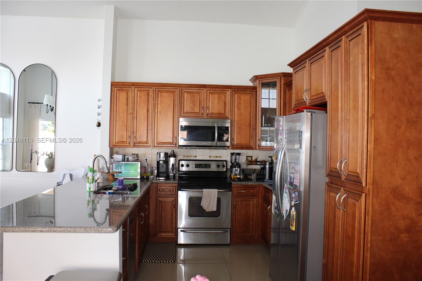 312 Bridgeton Road Weston, FL 33326 - Photo 4 of 13 a kitchen with stainless steel appliances granite countertop a refrigerator a stove top oven a sink and dishwasher