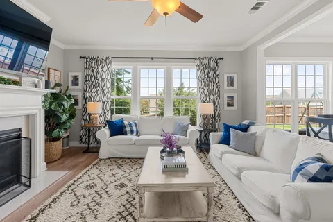 a living room with furniture fireplace and a large window