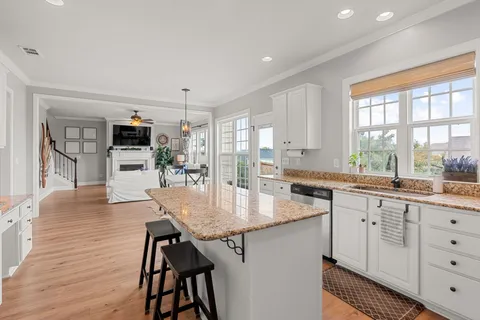 a kitchen with granite countertop a table chairs stove and cabinets