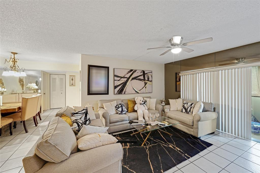 2710 Riverside Drive, Unit 106A Coral Springs, FL 33065 - Photo 4 of 8 a living room with furniture and a chandelier