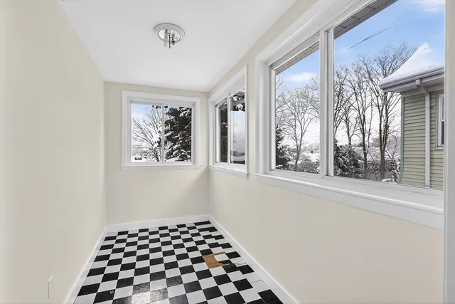a bathroom with a black white checkered floor and a window
