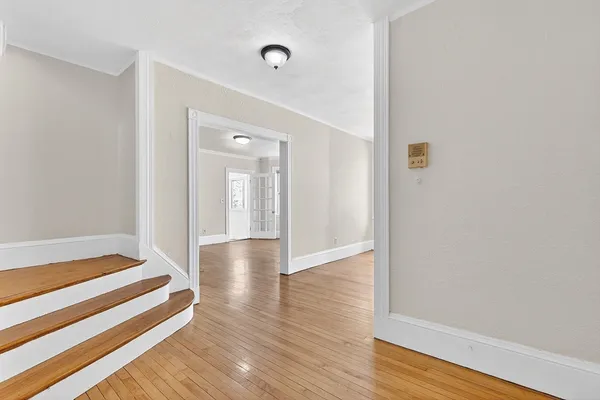 a view of a hallway with wooden floor and staircase
