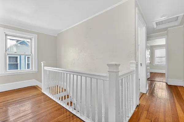 a view of a hallway with wooden floor and closet