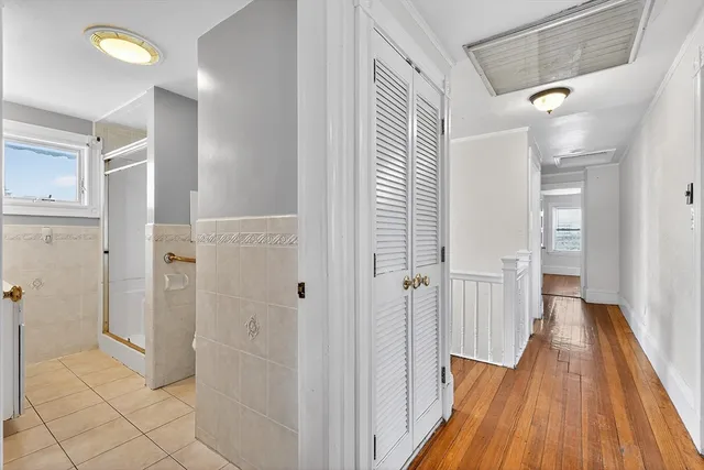 a view of a hallway with wooden floor and staircase