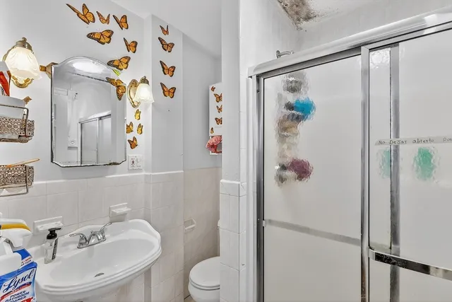 a bathroom with a sink and mirror with toilet