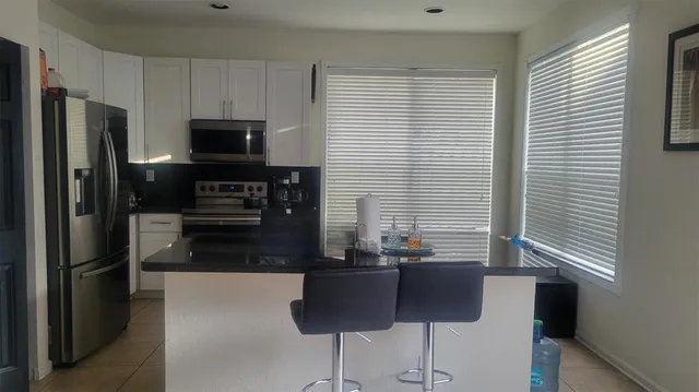 a kitchen with stainless steel appliances a refrigerator and a stove top oven