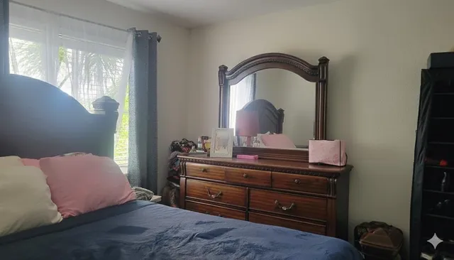 a bedroom with a bed and a mirror on dresser