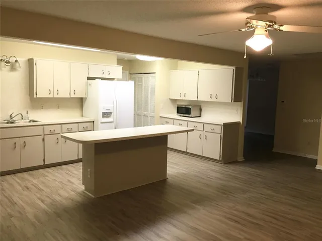 a kitchen with a sink cabinets and wooden floor
