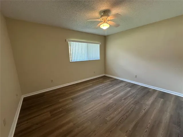 an empty room with a window and wooden floor