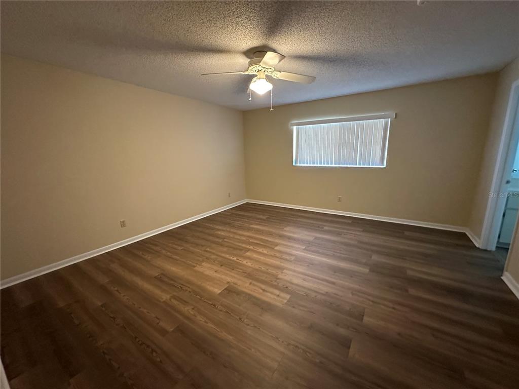 9157 Southwest 82nd Terrace, Unit C Ocala, FL 34481 - Photo 24 of 33 a view of an empty room with a chandelier fan