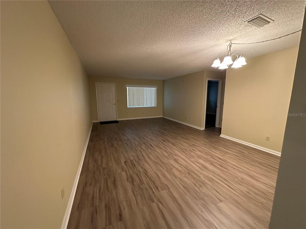 9157 Southwest 82nd Terrace, Unit C Ocala, FL 34481 - Photo 6 of 33 wooden floor in an empty room with a window