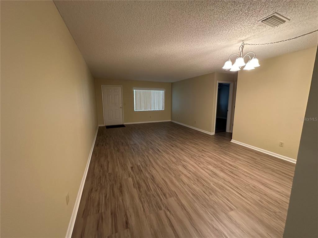 9157 Southwest 82nd Terrace, Unit C Ocala, FL 34481 - Photo 7 of 33 wooden floor in an empty room with a window