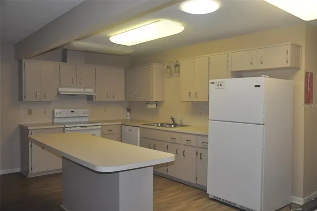 a kitchen with a sink a stove a refrigerator and a window