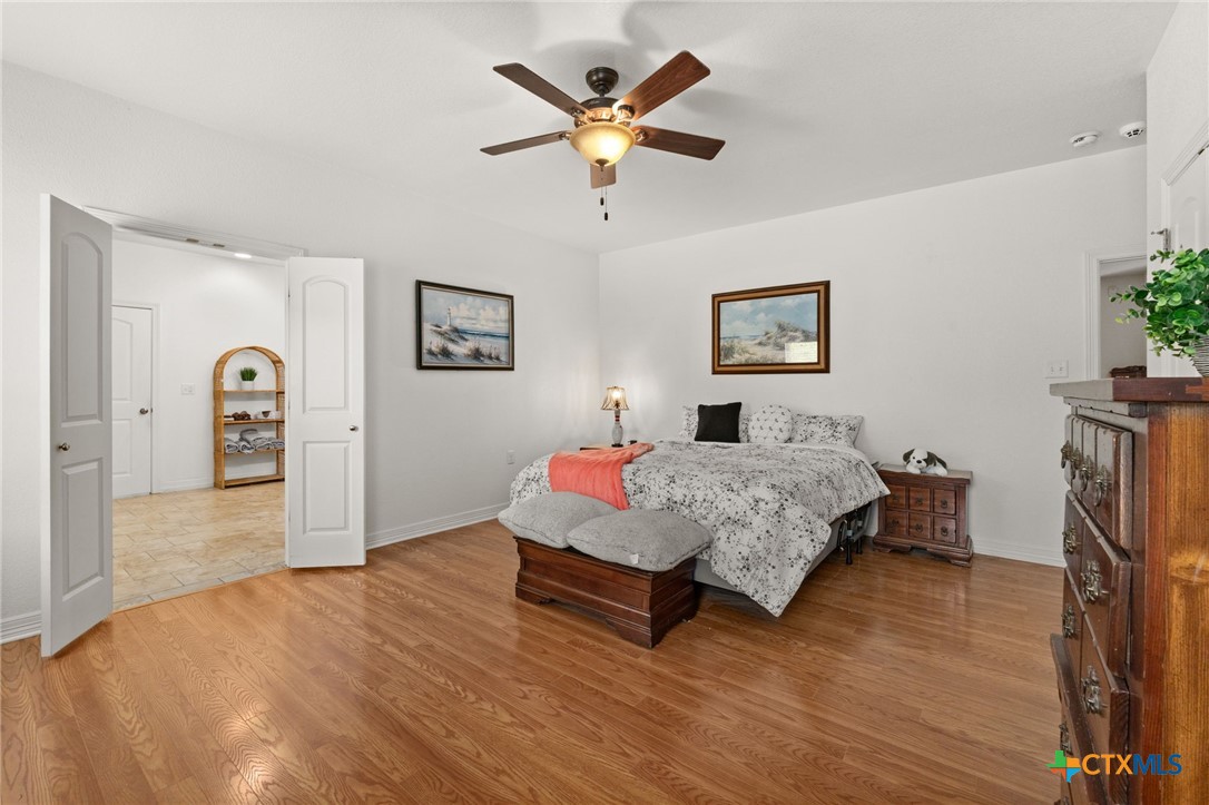 13061 Oakalla Road Killeen, TX 76549 - Photo 19 of 33 a bedroom with a bed and a chandelier