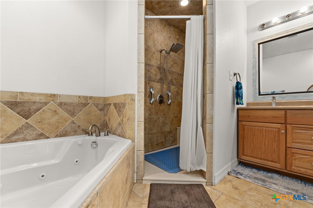 13061 Oakalla Road Killeen, TX 76549 - Photo 20 of 33 a bathroom with a tub a sink and a mirror