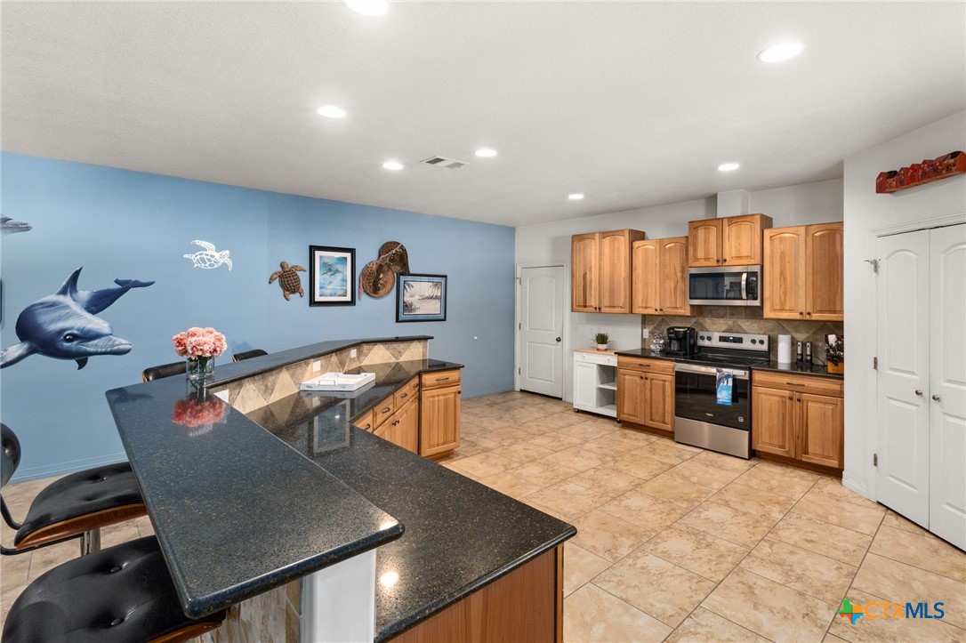 13061 Oakalla Road Killeen, TX 76549 - Photo 7 of 33 a kitchen with stainless steel appliances granite countertop a refrigerator a stove a sink a dining table and chairs