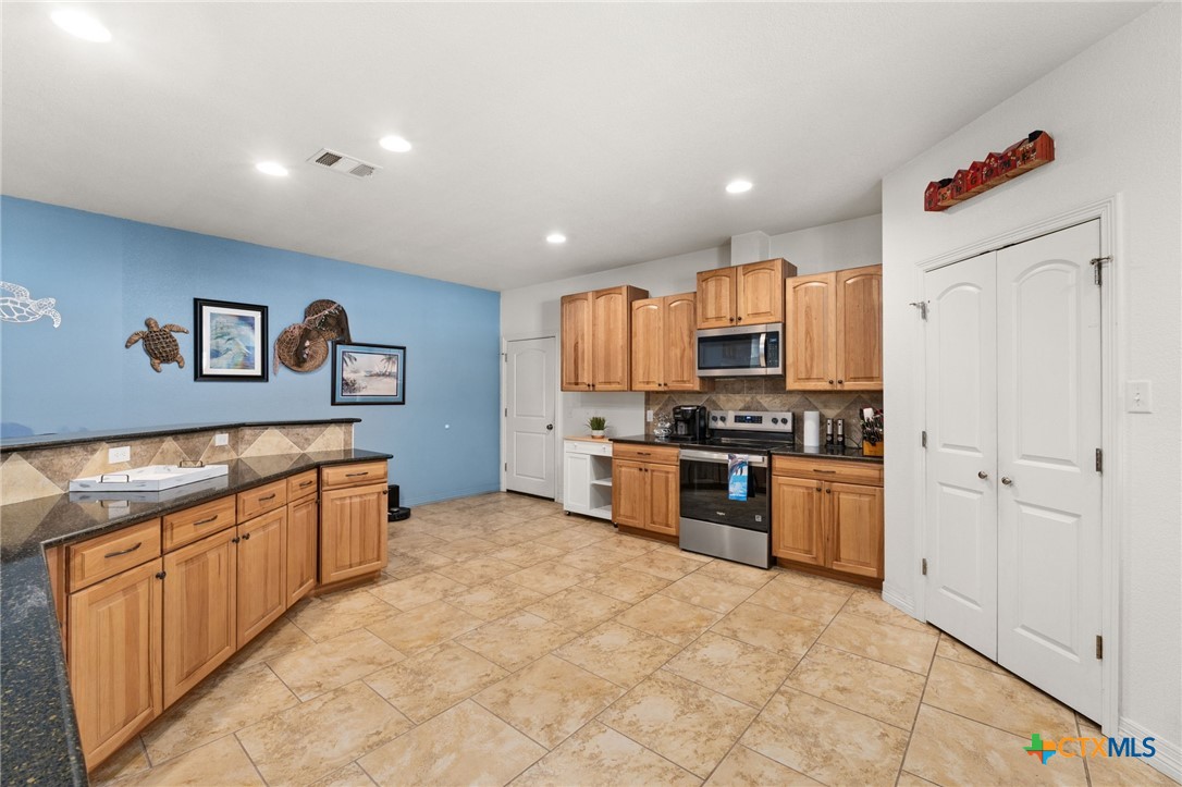 13061 Oakalla Road Killeen, TX 76549 - Photo 8 of 33 a kitchen with granite countertop a refrigerator and a stove top oven