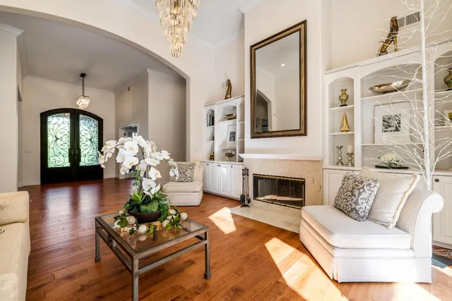 a view of a dining room with furniture a chandelier wooden floor and a chandelier
