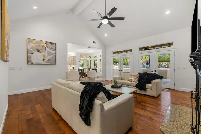 a spacious bedroom with a large bed a flat tv screen and dresser