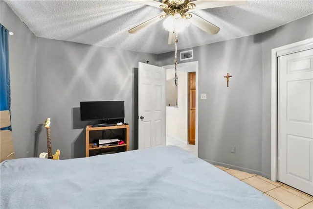 a bedroom with a bed and a flat tv screen on dresser
