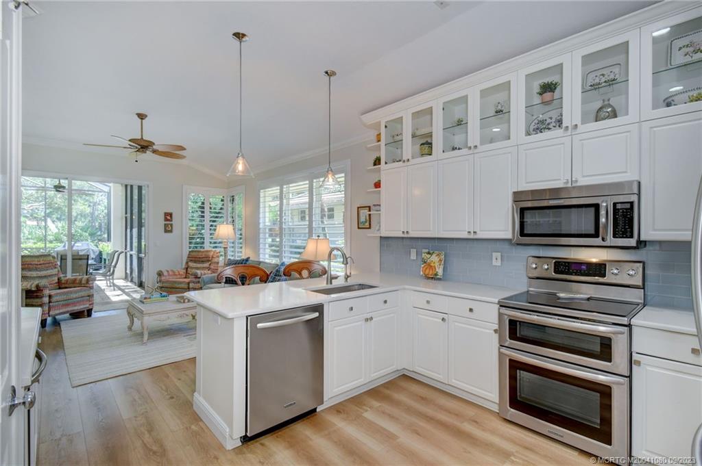 3531 Southeast Cambridge Drive Stuart, FL 34997 - Photo 11 of 44 a kitchen with a stove a sink and a refrigerator