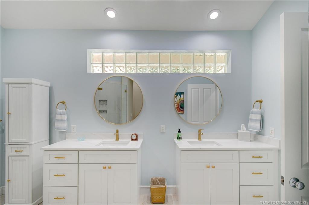 3531 Southeast Cambridge Drive Stuart, FL 34997 - Photo 19 of 44 a bathroom with a double vanity sink and a mirror