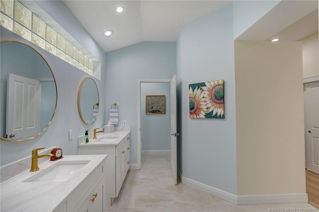 3531 Southeast Cambridge Drive Stuart, FL 34997 - Photo 20 of 44 a spacious bathroom with a double vanity sink mirror and bathtub
