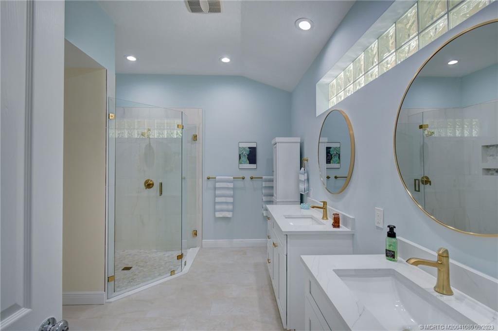 3531 Southeast Cambridge Drive Stuart, FL 34997 - Photo 21 of 44 a spacious bathroom with a double vanity sink mirror and shower