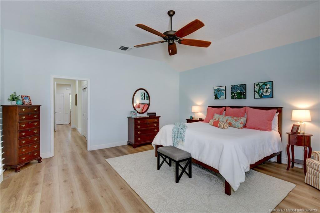 3531 Southeast Cambridge Drive Stuart, FL 34997 - Photo 25 of 44 a bed room with a bed and a chandelier
