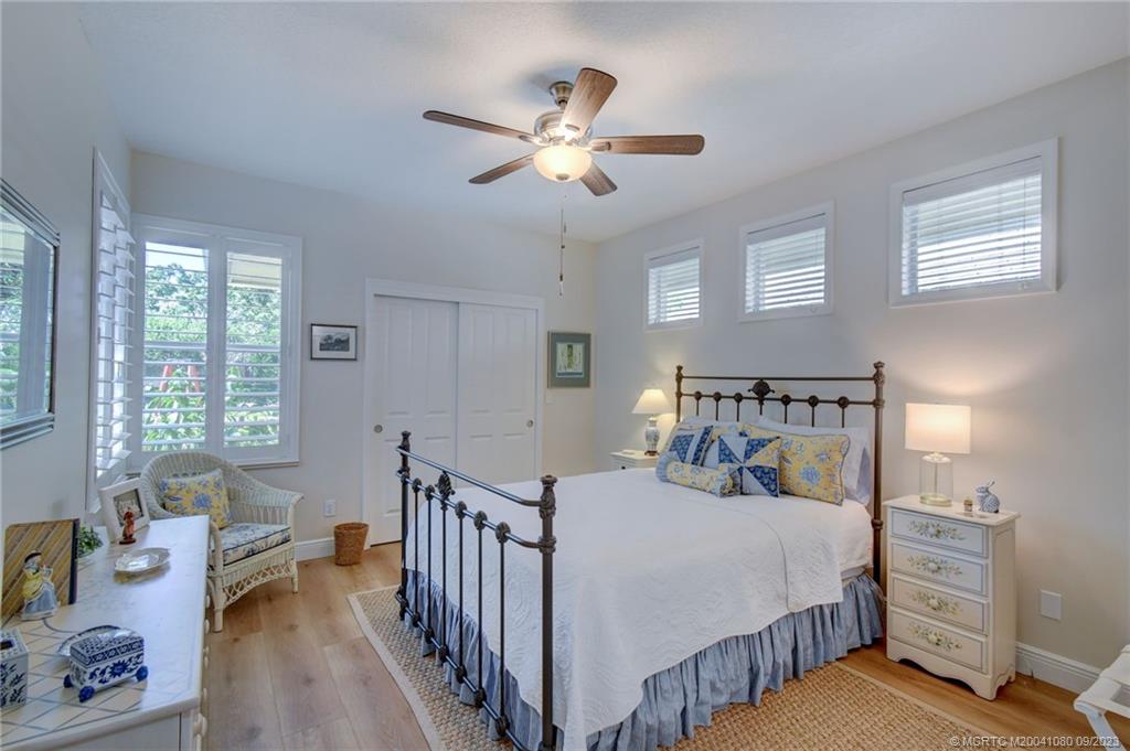 3531 Southeast Cambridge Drive Stuart, FL 34997 - Photo 26 of 44 a bedroom with a bed and a chandelier