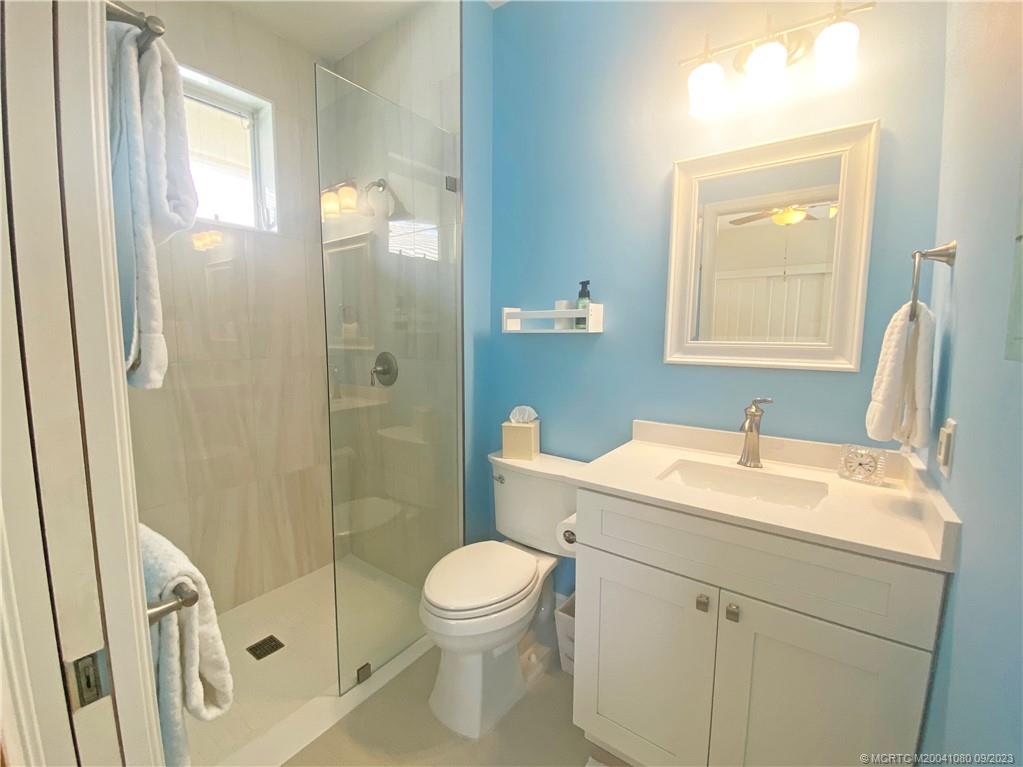 3531 Southeast Cambridge Drive Stuart, FL 34997 - Photo 27 of 44 a bathroom with a sink a toilet and shower