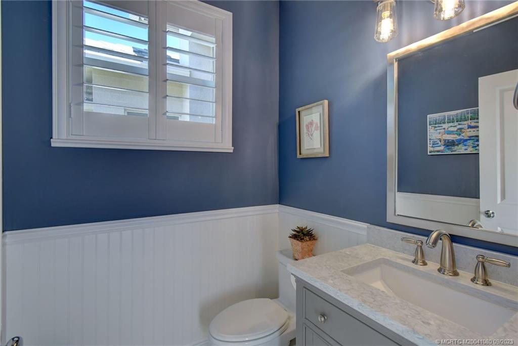 3531 Southeast Cambridge Drive Stuart, FL 34997 - Photo 31 of 44 a bathroom with a sink toilet and window