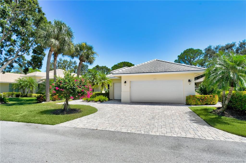 3531 Southeast Cambridge Drive Stuart, FL 34997 - Photo 4 of 44 a front view of a house with a yard and garage