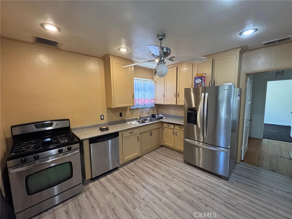 1418 West Magnolia Street Compton, CA 90220 - Photo 2 of 8 a kitchen with granite countertop a refrigerator and a stove top oven