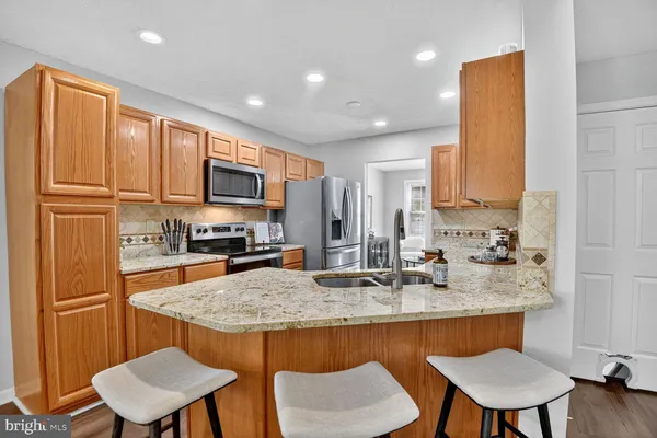a kitchen with a sink a kitchen island and chairs in it