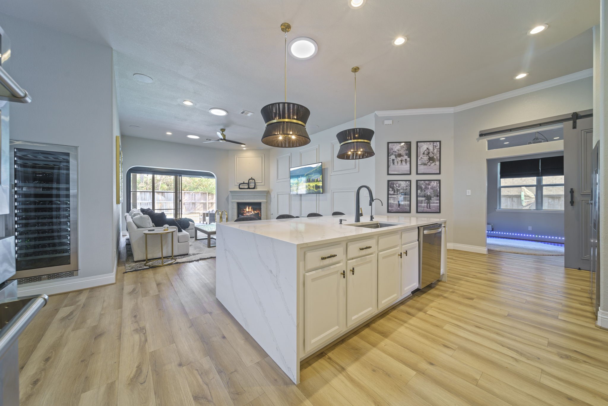 15 Inland Prairie Drive Tomball, TX 77375 - Photo 22 of 46 This open-concept kitchen and living area with hardwood floors and a large island. The living space includes a gas fireplace and large windows to the backyard space with natural light.