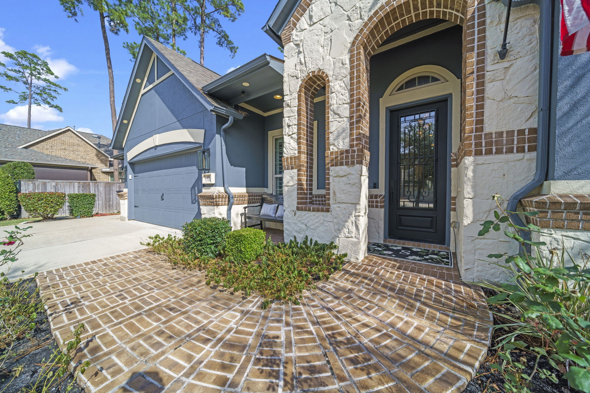 15 Inland Prairie Drive Tomball, TX 77375 - Photo 3 of 46 the entrance features a brick walkway and elegant stone accents. The arched doorway and modern garage add a touch of sophistication.