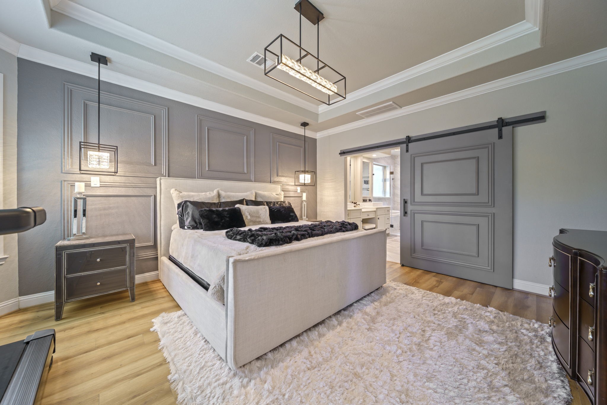 15 Inland Prairie Drive Tomball, TX 77375 - Photo 34 of 46 The primary bedroom has tall ceilings with a lot of natural light, beautiful floors and a large sliding barn door to the bathroom.
